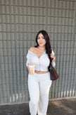 Model wearing a white zip-front top and wide-leg pants set