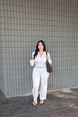 Side view of a model wearing a white matching two-piece set